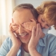 Middle aged man with his eyes covered by a small boy