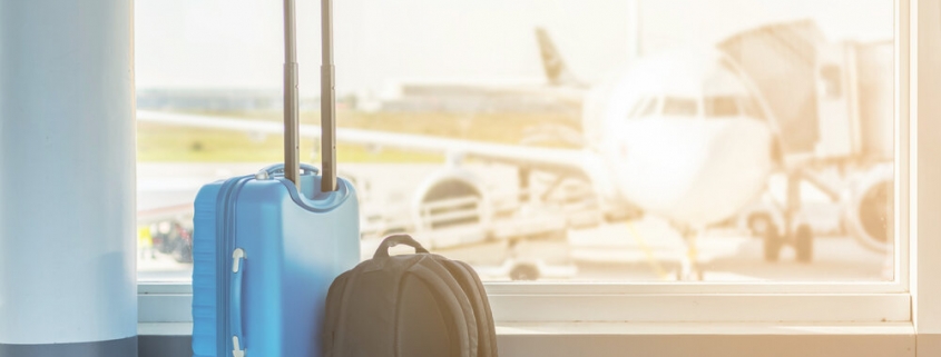 Hand luggage at the airport in front of an airplane