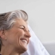 Woman and daughter smile at each other in hospital room