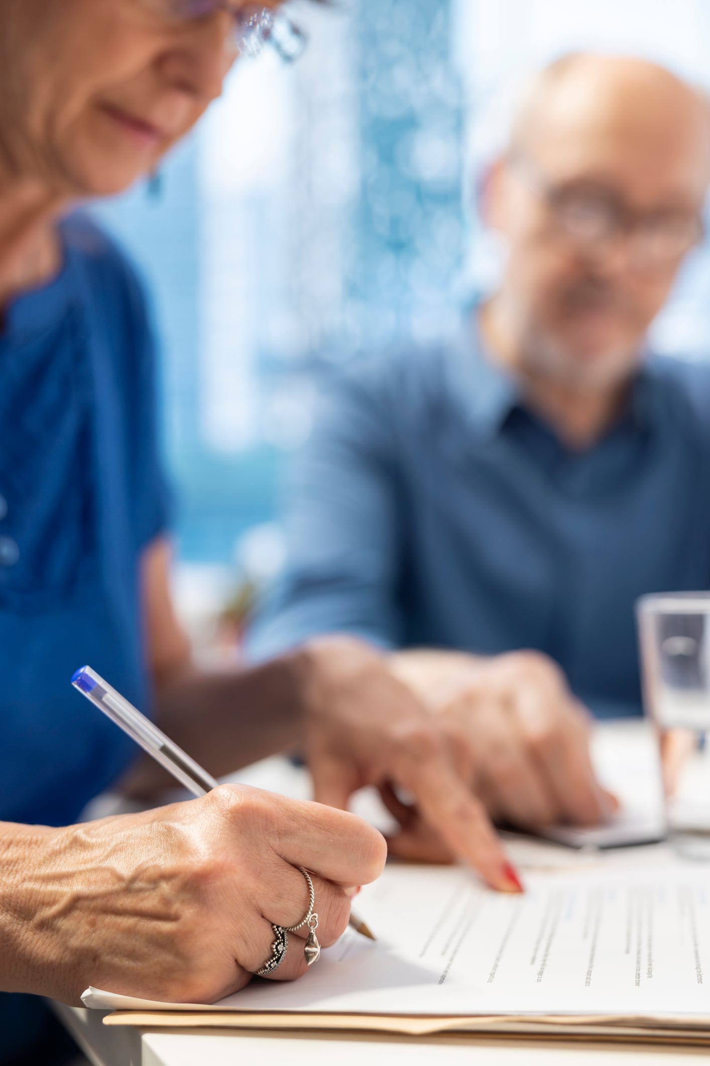 Mature person signing the financial contract in modern office Mature person signing the financial contract in modern office