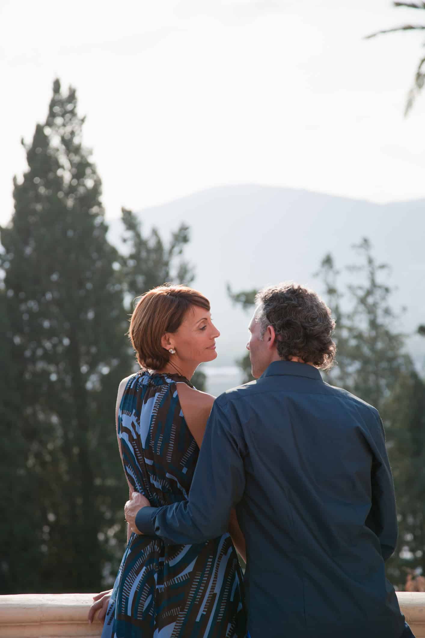 Nicely dressed couple shares moment in mountain garden setting Nicely dressed couple shares moment in mountain garden setting