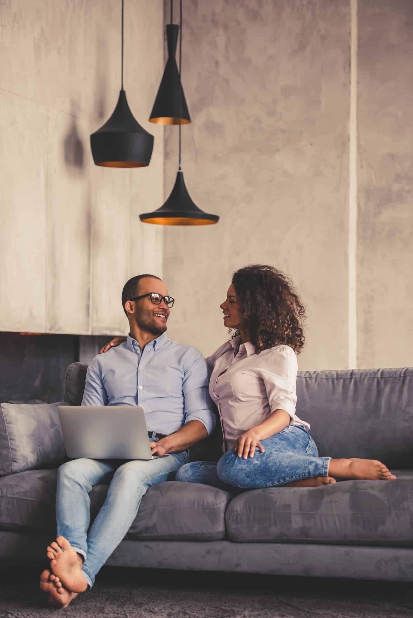 Couple smiles at each other on the couch Couple smiles at each other on the couch